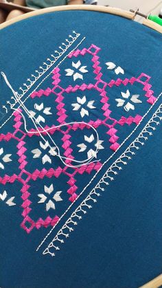 a close up of a blue piece of cloth with pink and white designs on it