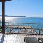 an outdoor table and chairs overlooking the ocean