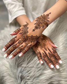 two hands with henna tattoos on them