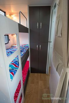 bunk beds in a small room with wood flooring