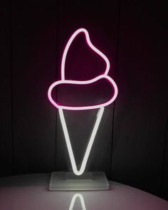 a neon sign with a hat on it in the middle of a dark room that appears to be lit up