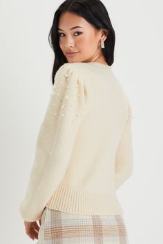 The Lulus Undeniable Glow Ivory Pearl Pullover Sweater will be your favorite way to make yourself shine this holiday season! This stunning sweater has a slightly fuzzy medium-gauge knit construction, with gleaming faux pearl details throughout, that shapes a classic crew neckline, long balloon-style sleeves with fitted cuffs, and a relaxed bodice. Contrasting ribbed knit accents the neckline, cuffs, and hem. Fit: This garment fits true to size. Length: Size medium measures 17.75" from shoulder t Beige Winter Party Sweater, Cream Party Tops For Winter, Cream Winter Party Top, Chic Jacquard Knit Crew Neck Sweater, Pearl Collar Sweater, Pearl Button Sweater, Cream Jacquard Knit Long Sleeve Tops, Cream Long Sleeve Jacquard Knit Top, Ivory Sweater