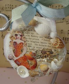 an ornament with a mermaid and seashells on it