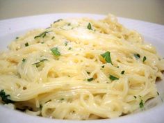 a plate of pasta with parmesan cheese and spinach