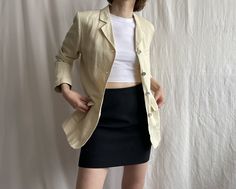 "Vintage linen blend blazer with utility pockets in soft butter yellow tone. Button closure, notch lapel collar, lined. ✏️ TAGS GLOBAL Size 38 55% linen 45% viscose 100% acetate lining ✂️ CONDITION  good vintage condition, few minor stains and crease lines cleaned and ready to wear. 📏 MEASUREMENTS Measured laying flat, please double for circumference:   length  28 1/2\" 72 cm shoulders 16\" 40.5cm bust 19 1/2\" 49.5cm sleeve 24\" 61cm 📌 PLEASE NOTE  If you're in doubt, please ask for more measurements or information. Although we try our best to reflect colors accurately, there might be slight differences in their appearance on your screen. Model is 5'6\"/170cm tall with measurements 31-26-35 inches (79-66-89 cm) and wears size S All bemydear garments are pre-owned and may display minor s Summer Notch Lapel Blazer With Buttons, Summer Blazer With Notch Lapel And Buttons, Summer Fitted Button-up Blazer, Summer Office Blazer With Buttons, Beige Blazer With Pockets For Summer, Tailored Summer Blazer With Button Closure, Cream Summer Outerwear For Office, Summer Cream Classic Blazer, Summer Office Button-up Blazer