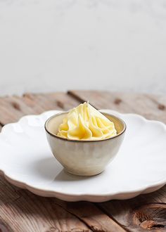 a white bowl filled with food on top of a wooden table