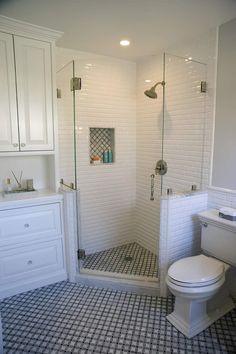 a white toilet sitting next to a walk in shower