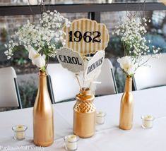 there are three vases with flowers in them on the table at this wedding reception