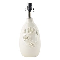 a white vase with flowers on it and a black holder in the shape of a flower