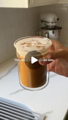 someone holding up a cup of coffee in their hand with the caption, this is salted by ice cream latte