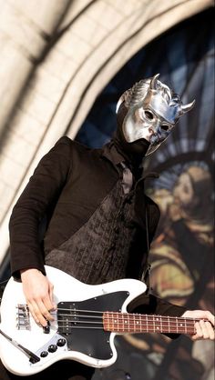 a man in a mask playing a bass guitar