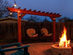 an outdoor fire pit with chairs around it