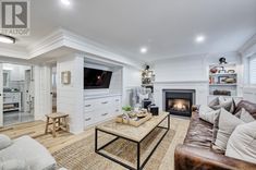 a living room filled with furniture and a flat screen tv mounted on the wall above a fire place