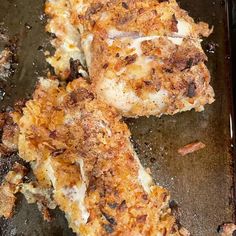 two pieces of fried chicken sitting on top of a pan