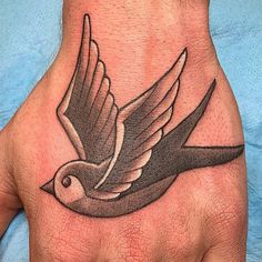 a hand with a bird tattoo on it