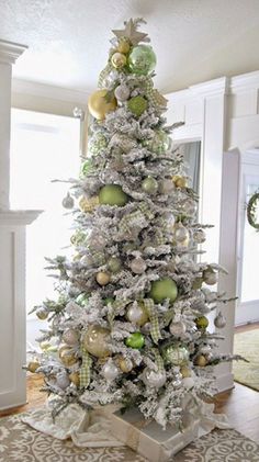 a white christmas tree with gold and green ornaments