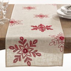 a table with a red and white snowflake design on it, next to some wine glasses