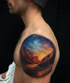 a man's upper half sleeve with an image of mountains and stars in the sky