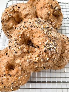 three sesame seed donuts on a cooling rack