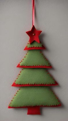 a felt christmas tree ornament hanging on a wall