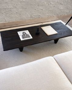 a coffee table with an open book on it and a pen resting on one end