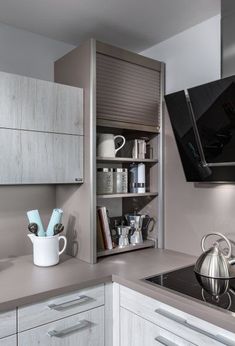 a kitchen with white cabinets and stainless steel appliances, including a dishwasher on the wall