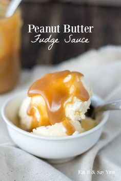 a bowl filled with ice cream covered in caramel sauce next to a jar of peanut butter fudge sauce