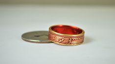 "1938 Japanese 1 Sen Coin Ring w/Red nanoceramic: - Glowing Brass Coin Ring - Your choice of Nano Ceramic Color. (see the second photo) - Comes in a cute box ready for gift giving. - Made to order, just for you. These rings are handcrafted using a rare brass Japanese One Sen Coin. Issued only in 1988 they feature a beautiful wave and cherry blossom design that will be on the outside of the ring. The inside of the ring features the date and issuing authority in Japanese script. You can see the co Bohemian Red Anniversary Rings, Unique Red Enamel Ring As Gift, Unique Red Enamel Ring For Gift, Unique Red Enamel Ring As A Gift, Japanese Script, 21st Anniversary, Red Ring, Red Rings, Bohemian Ring