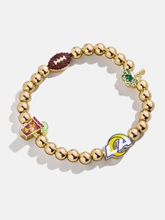 The Los Angeles Rams NFL Charm Bracelet is the ultimate accessory for die-hard footballl fans. Each bracelet is a celebration of your favorite team, featuring the Rams logo along with other charms related to the team and its iconic location. Perfect for game days or everyday wear, this bracelet adds a touch of sports-inspired elegance to any outfit. This bracelet features 6mm gold ball beads. This is an officially licensed NFL product. Team-colored Sports Event Bracelets, Sporty Team-colored Jewelry For Game Day, Sporty Jewelry For Game Day, Adjustable Bracelets For Game Day, Football Season, Rams Logo, Beaded Charm Bracelet, Gifts For Football Fans, Birthday List, Los Angeles Rams