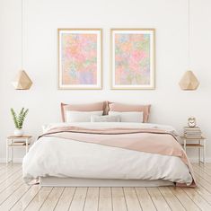 a bedroom with two paintings above the bed