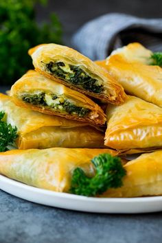 some food is on a plate with broccoli and cheese in the middle that says homemade spanakopita