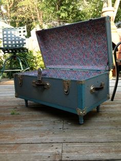 an old trunk sitting on top of a wooden deck