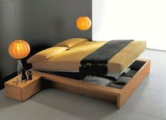 a bed with two lamps hanging from it's sides