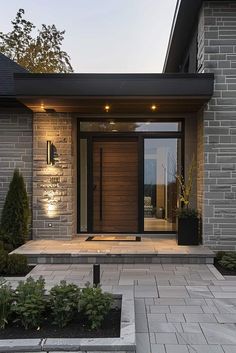 the front entrance of a modern home with stone steps