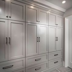 a kitchen with white cabinets and gray counter tops