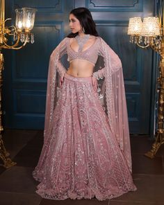 A modern bridal lehenga hand embellished with pearls, crystals, sequin, and cutdana embroidery. Paired with a full sleeves embroidered blouse with all-over dangling tassel detailing on the sleeves and an embroidered cutwork dupatta with a border. Additional dupatta available upon request.DELIVERY TIMEPlease allow 8-12 weeks for your outfit to arrive.FABRIC DETAILSNetProfessional cleaning only. Modern Bridal Lehenga, Pink Bridal Lehenga, Pink Bridal, Modern Bridal, Dusky Pink, Indian Fashion Designers, Pernia Pop Up Shop, Full Sleeves, Bridal Lehenga