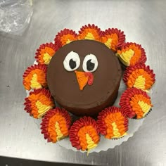 a chocolate cake decorated like a turkey with orange and red ruffles around it