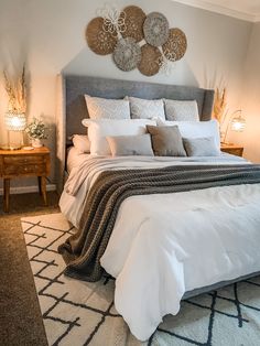 a large bed sitting in a bedroom next to two lamps and a rug on the floor