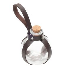 a small glass bottle with a cork top and brown leather strap around the neck, on a white background