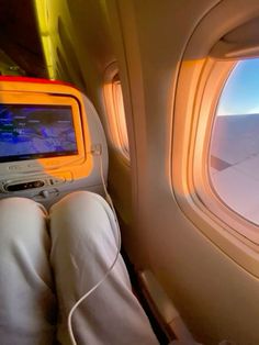 the view from inside an airplane looking out at the wing and window with someone's feet propped up in front of them