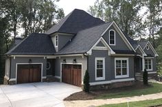 a gray house with white trim and two garages