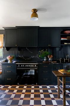 a kitchen with black cabinets and checkered flooring on the floor is pictured in this image