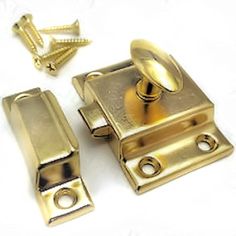 two brass plated cabinet doors with screws on the bottom and one door handle