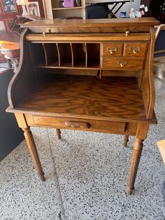 an old wooden desk with some drawers on the top and one drawer open to show what's inside