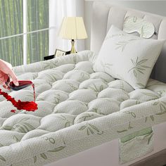 a person is cleaning the mattress with a red brush and cloth on top of it