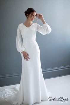 a woman in a white wedding dress posing for the camera