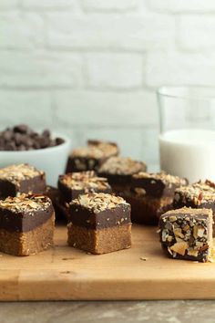 chocolate fudge brownies cut into squares on a cutting board next to a glass of milk