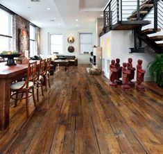 an open floor plan with wooden floors and stairs