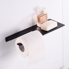 a roll of toilet paper sitting on top of a black shelf