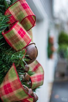 a christmas tree with bells hanging from it's sides and ribbon on the top